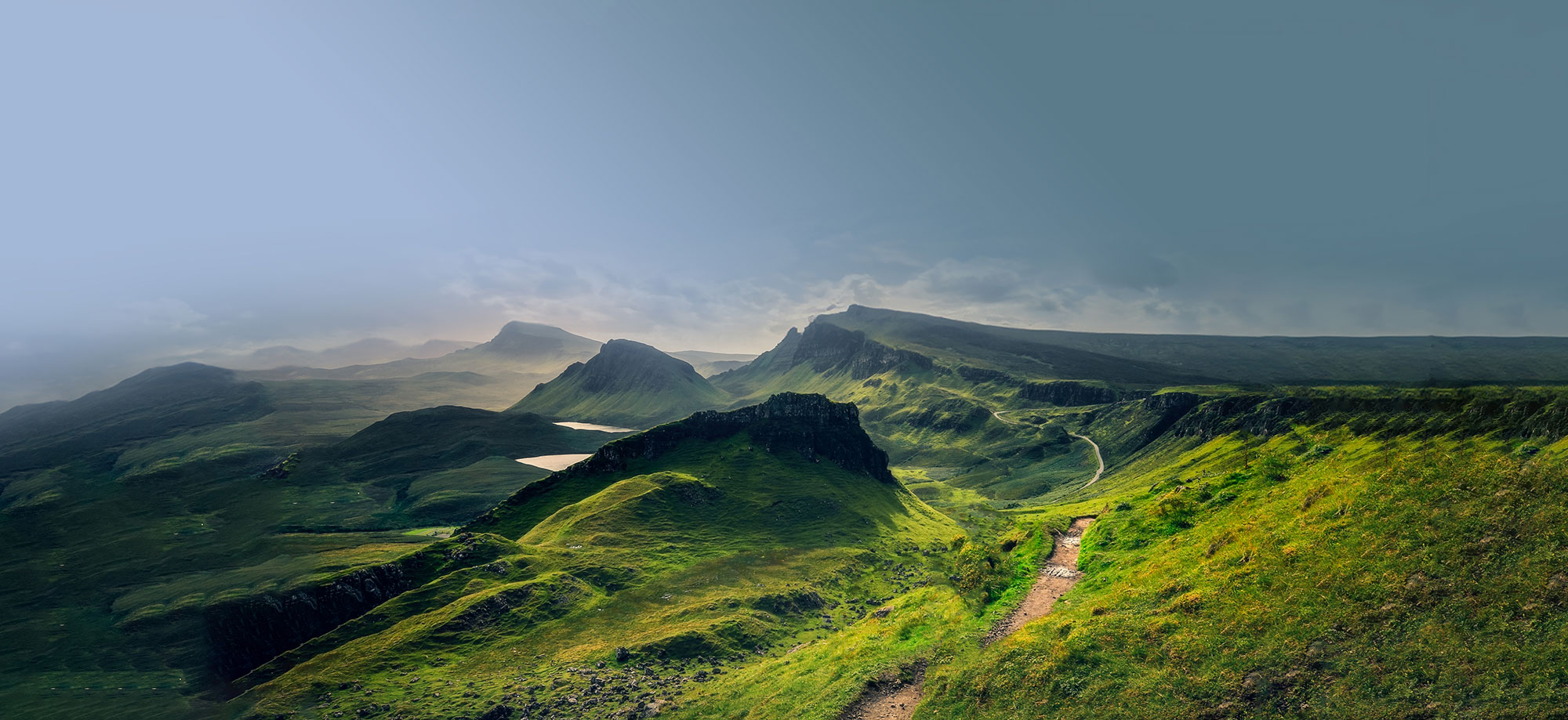 A scenic landscape by Harper McDermott depicts rolling green hills and distant mountains under a cloudy sky, with a winding path leading through the terrain.